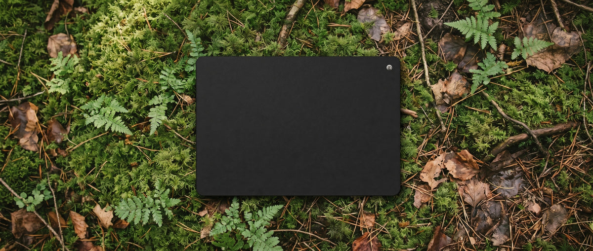 Tapis de mise à la terre Ancorya posé sur un sol de forêt, vu du dessus