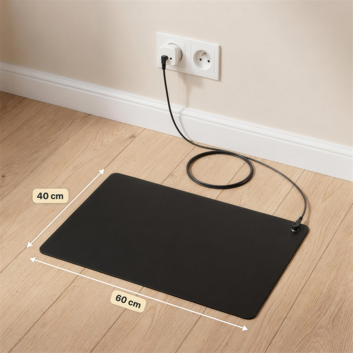 Installation du tapis Ancorya : tapis 60 x 40 cm posé sur le parquet, cordon noir relié à l'adaptateur de terre branché sur une prise murale.