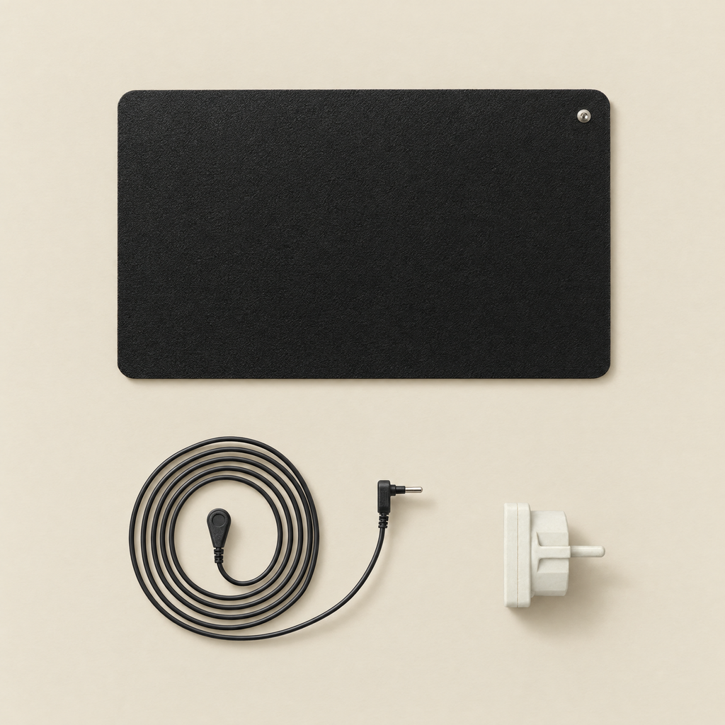 Contenu de la boîte Ancorya : tapis de mise à la terre noir 60 x 40 cm, cordon noir avec connecteur à pression, adaptateur de terre blanc.